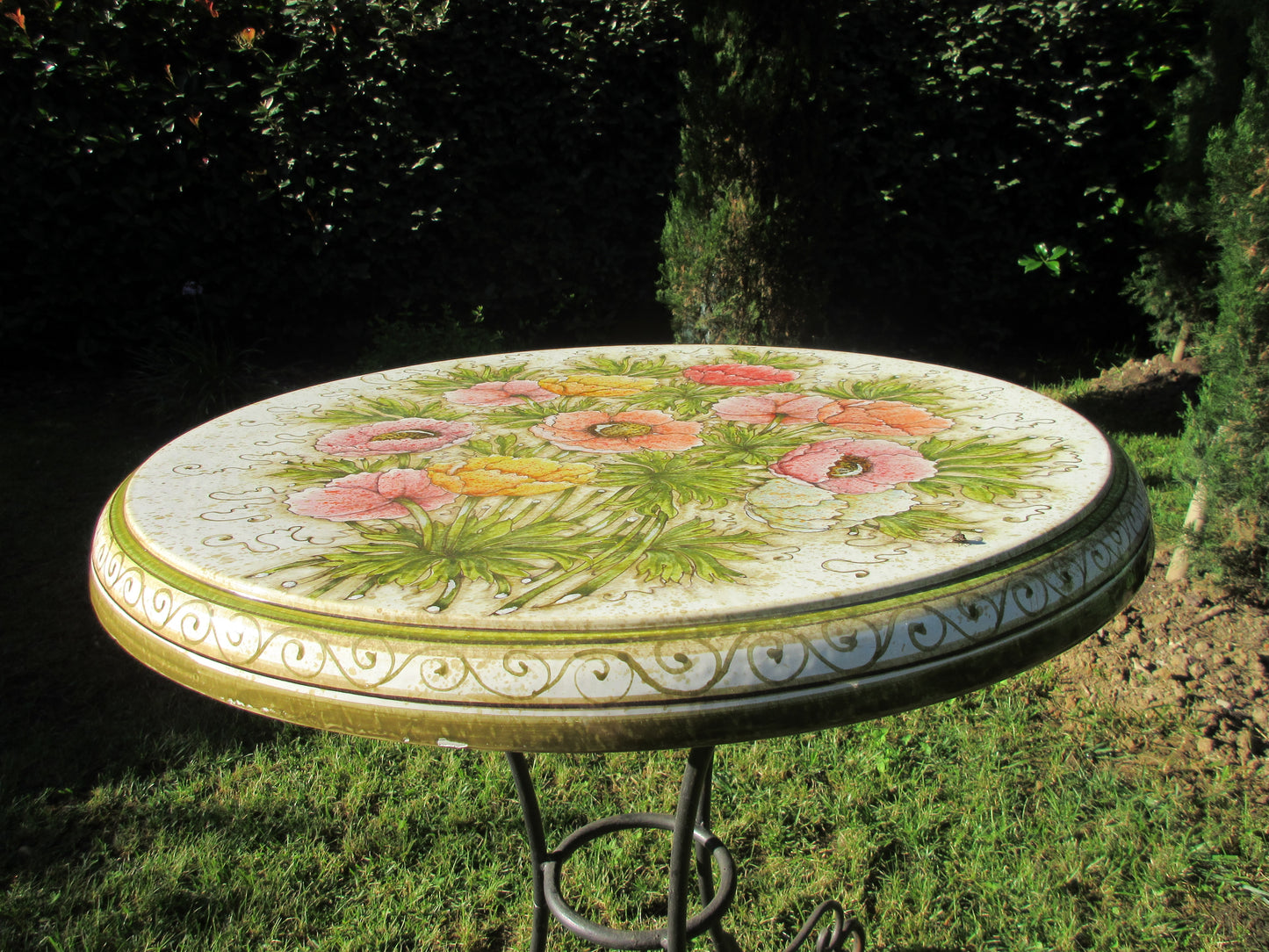 Tavolo in ceramica tondo con disegno di anemone e base in ferro