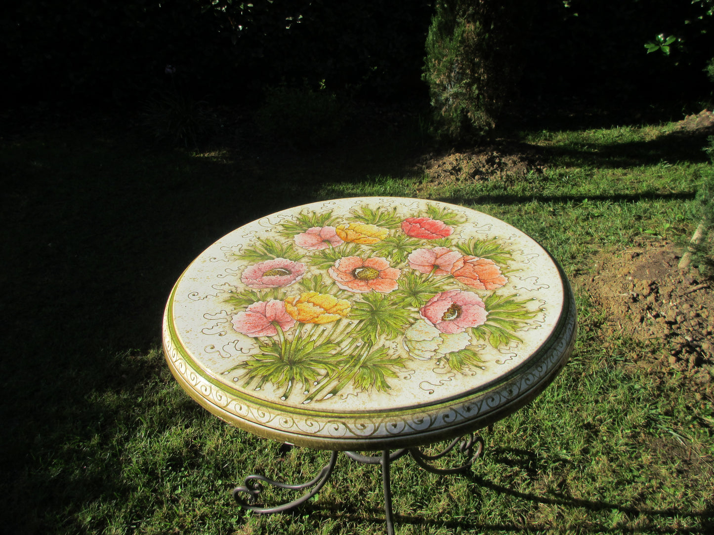 Tavolo in ceramica tondo con disegno di anemone e base in ferro