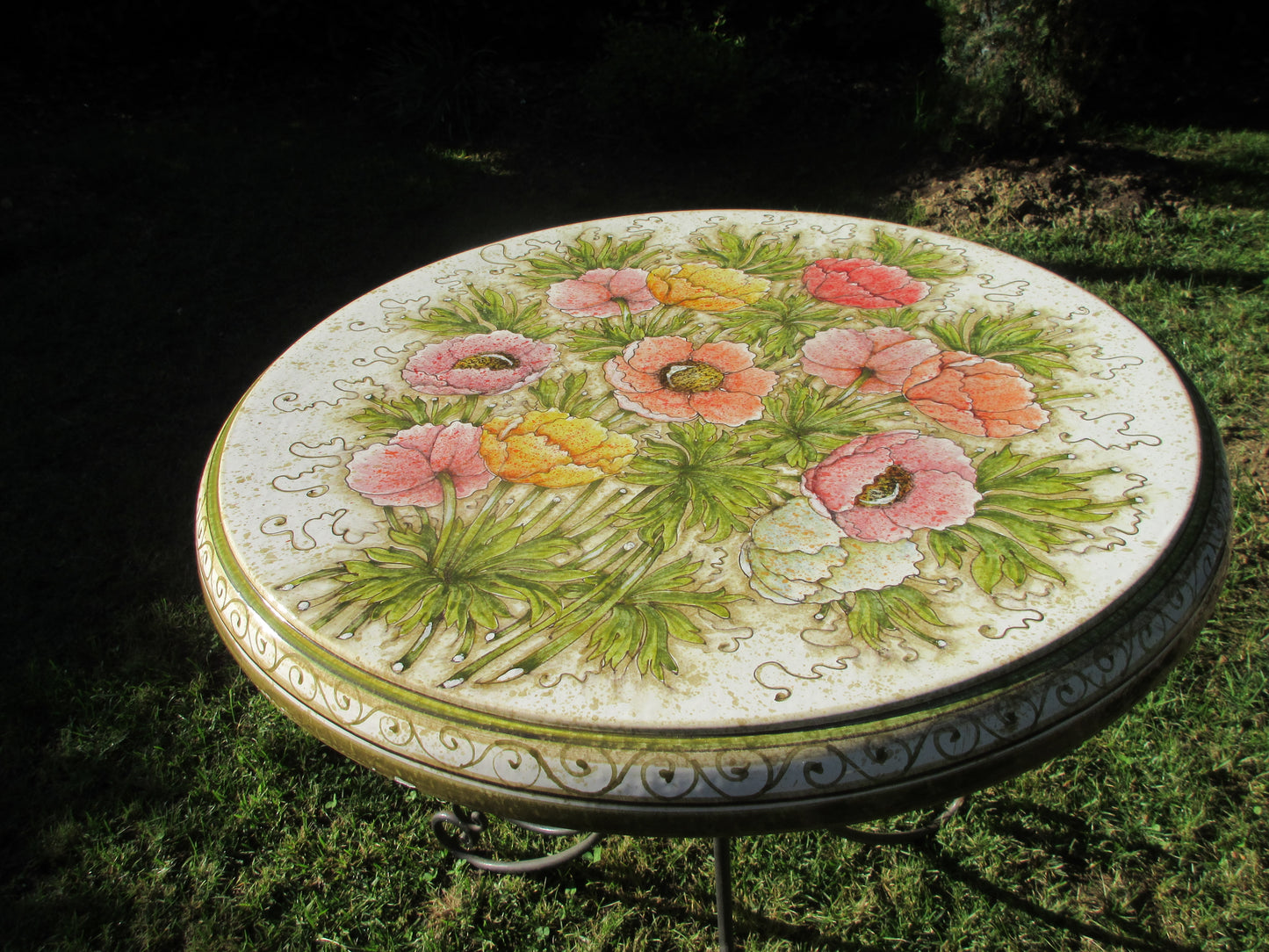 Tavolo in ceramica tondo con disegno di anemone e base in ferro